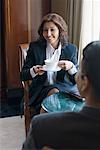 Rear view of a businessman sitting in front of a businesswoman and holding a cup of tea