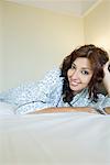 Portrait d'une jeune femme allongée sur le lit