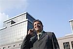 Low angle view of a businessman talking on a mobile phone and smiling