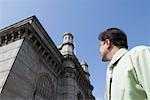 Low angle view of a businessman in front of a monument, Gateway of India, Mumbai, Maharashtra, India