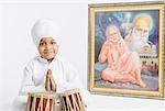 Portrait of a boy sitting in front of bongo and praying