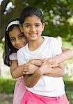 Portrait of a girl hugging another girl and smiling