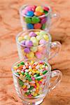 Zeile der drei Tassen gefüllt mit Jelly Beans und Süßigkeiten