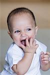 Close-up of a baby boy laughing and looking away