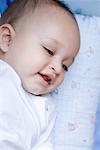 Close-up of a baby boy lying down and smiling