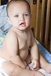 Portrait of a baby boy sitting in a crib