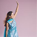 Mid adult woman standing in salwar kameez and waving her hand