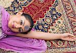 Portrait of a mid adult woman lying on a carpet in salwar kameez