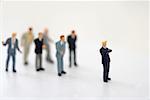 Businessman figurine standing beside a group