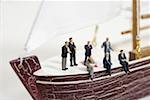 Businessmen figurines on a miniature ship