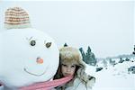 Teen girl sharing scarf with snowman