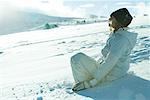 Jeune fille assise sur la neige