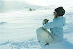 Teen fille assise sur la neige en position de prière