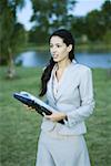 Femme d'affaires, se promenant dans le parc avec laZSop