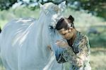 Jeune femme se pencher sa tête contre le cheval