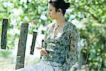 Young woman holding branch in rural setting