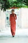 Junge Frau tragen traditionellen chinesischen Kleidung, walking mit Sonnenschirm