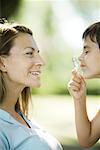 Mother and son, boy looking through magnifying glass, side view, close-up