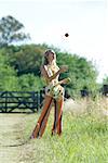 Jeune femme debout dans le champ, jonglerie de pommes