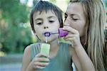 Mother and son blowing bubbles together