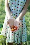 Junge Frau hält sich Cherry-Tomaten, geschnitten