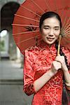Jeune femme habillée en costume traditionnel de la Chine, sous le parasol, portrait