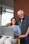 Father and Daughter with Laptop on Porch of Farmhouse