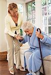 Senior Woman Receiving Assistance with Getting out of Chair