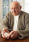Senior homme regardant pilulier