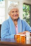 Portrait de femme Senior avec bouteilles de pilules