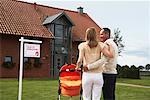 Couple Standing in Front of House