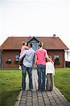 Family Standing in Front of House