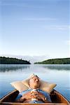 Mann schlafen im Kanu auf See, Haliburton, Ontario, Kanada