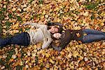 Portrait de Couple couché dans les feuilles d'automne