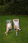 Couple assis dans des chaises de jardin