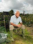 Mature Man Sitting on Chair in Garden