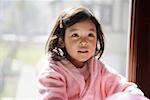 Girl wearing bathrobe, looking up