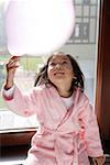 Girl playing with a balloon, smiling, looking up