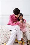 Mother helping her daughter to set alarm on the timepiece