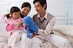 Family playing with a puppet in the bedroom