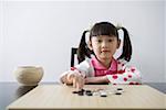 Girl playing weiqi game board, portrait
