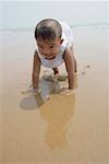 Boy playing in sand, smiling, portrait