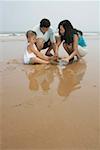 Parents with son playing in sand on beach