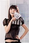 Portrait of a young woman holding paper currency and purse