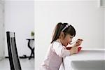 Girl drinking soup with a spoon