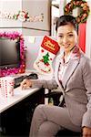 Portrait d'une femme d'affaires assis de pc de bureau et souriant au bureau