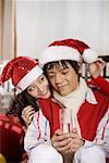 Young couple drinking water in Christmas hats