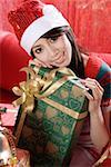Young woman holding a Christmas gift box, smiling