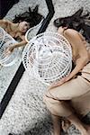 Young woman lying by metal birdcage, elevated view