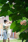 Young couple smooching with leaves in foreground